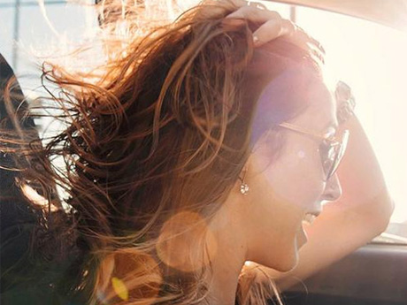 Woman with hair blowing in car